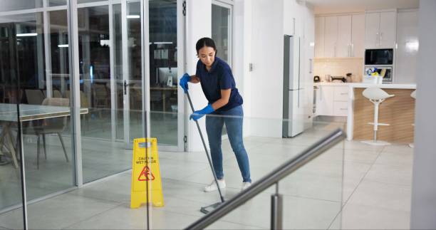 Woman, cleaner and mopping floor in office for fumigation, disinfect and safety suit from disease risk in building. Maintenance, female person and chemical liquid of pest control, health and hygiene